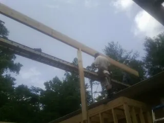 Carpenter setting a ridge beam over a new addition frame — Ice Dam Removal by Roofing Brothers in Gallitzin