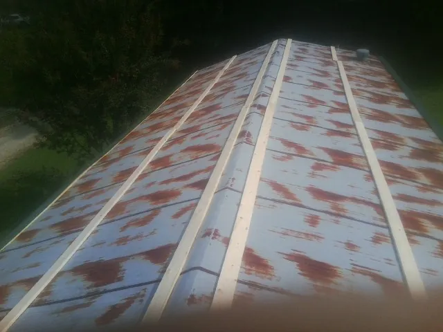 Rusted metal roof panels with new wood purlins before replacement — Storm Damage Roof Repair in Gallitzin by Roofing Brothers