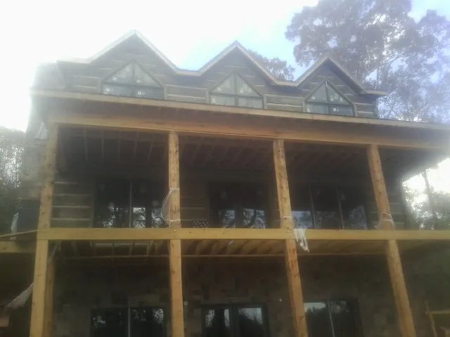 Dormers and porch framing on a large log home under construction — Roof Coating work by our crew in Gallitzin