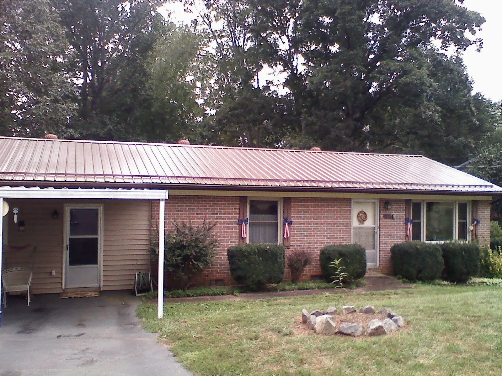 Bronze metal roof and carport on a brick ranch home — Roof Repair work by our crew in Gallitzin